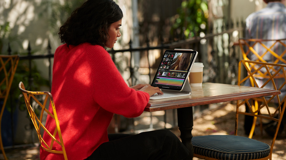 En kvinde, der bruger iPad Pro med det hvide Magic Keyboard. 