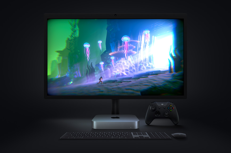 The video game “Little Orpheus,” running on Mac mini, is displayed on a monitor, with a wireless keyboard and mouse and Xbox controller nearby.
