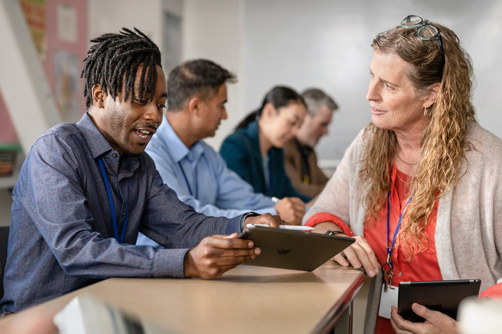 Una educadora del programa Apple Learning Coach ayuda a un profesor a usar el iPad.