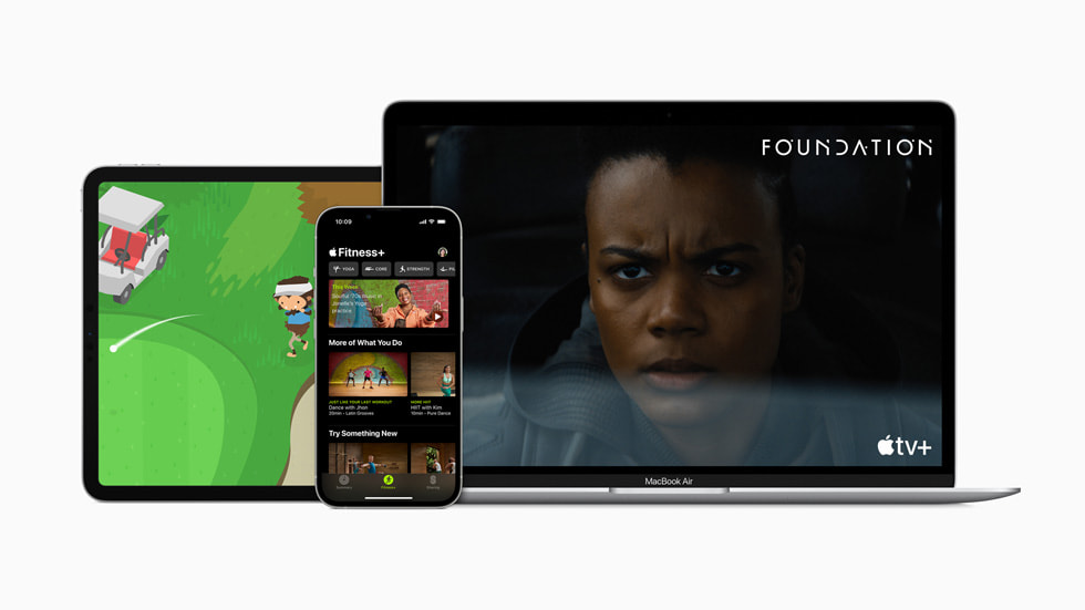 Apple Arcade auf einem iPad Pro, Fitness+ auf einem iPhone 13 Pro und Apple TV+  auf einem MacBook Air. 
 