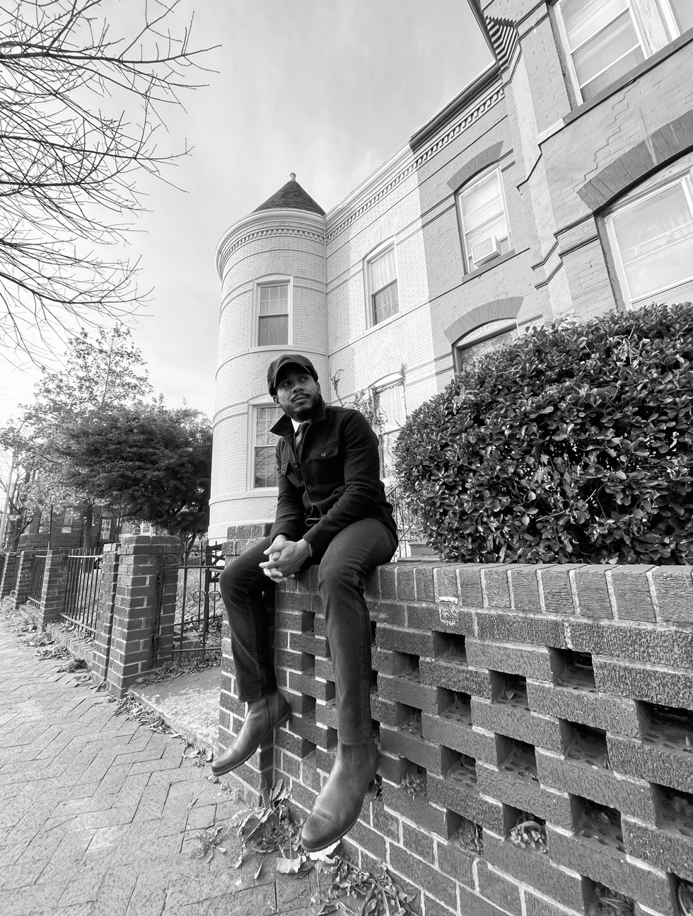 Chris, seated on a brick fence.