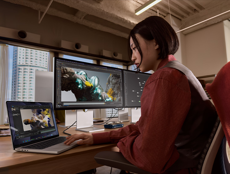 บุคคล 2 คนอยู่ในห้องที่มีแสงสว่างเพียงพอ โดยคนหนึ่งกำลังดูคำสั่งซื้อบน iMac สีเขียวพร้อมชิป M4