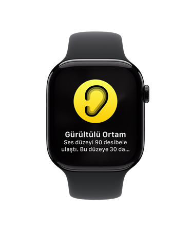 Beyaz Spor Kordonlu Apple Watch Series 10’un önden görünümü, Kullanıcı Arayüzünde Gürültü Bildirimi simgesi görülüyor ve Gürültülü Ortam, ses düzeyi 90 desibele ulaştı yazıyor.