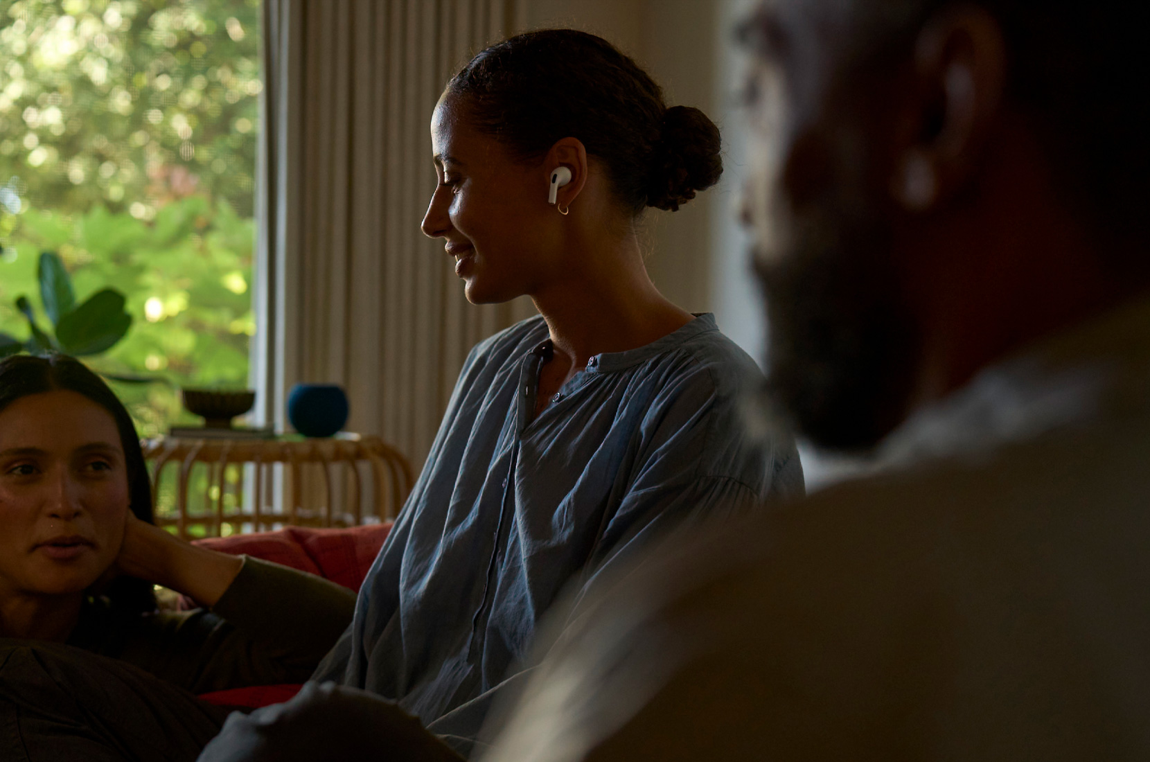 Photo of side profile view of a woman wearing AirPods Pro 2 in left ear and using Hearing Health feature