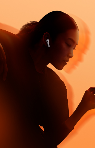 A person wearing AirPods 5, arms bent, multi-colour background