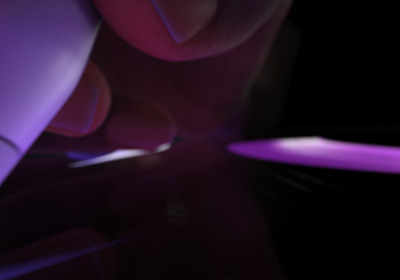 Użytkownik trzymający Apple Pencil Pro w ustawieniu do pisania. Dociśnięta do wyświetlacza końcówka rysuje grube pociągnięcia w kolorze jasnozielonym.