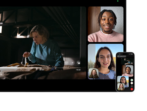 Mac und iPhone: Split View mit SharePlay auf dem Mac, eine Apple TV Serie wird auf der linken Seite wiedergegeben, FaceTime Fenster auf der rechten Seite zeigen drei Personen, das iPhone, das neben dem Mac befestigt ist, wird als Integrationskamera verwendet