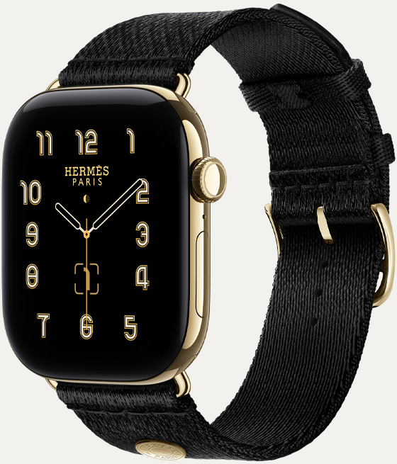 Apple Watch Hermès Series 12, den analoga urtavlan Clou de Selle (timvisare, minutvisare och sekundvisare, komplikationer: månfas, datum), titanboett i färgen skinande guld, höger utsida, Digital Crown, sidoknapp, kombinerad med Satin Clou de Selle-armband i Noir, slätt, svart sidenmatt vävt material med spänne i skinande guld som matchar boetten