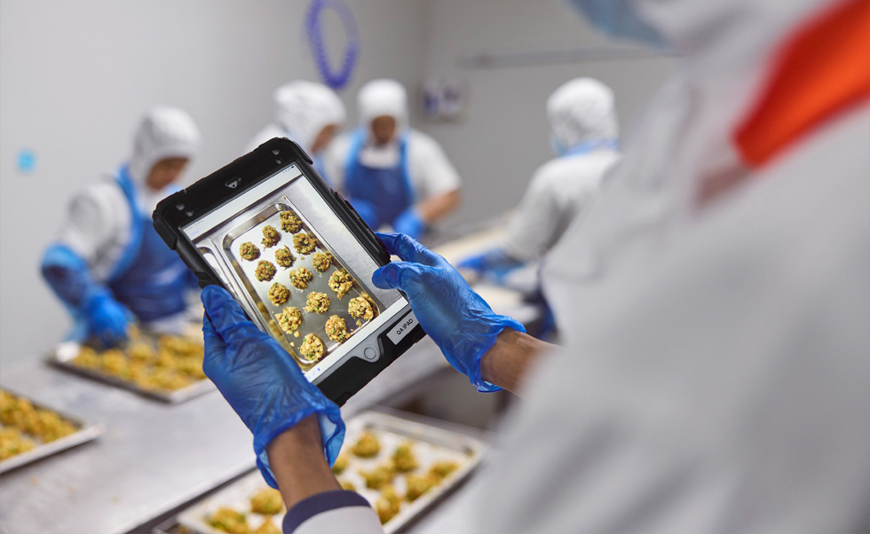 Seorang karyawan memastikan kontrol kualitas di iPad.