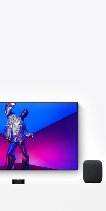 Apple TV 4K และ HomePod, สีดำ, หน้าจอทีวีแสดงนักดนตรีที่แต่งตัวสีเงินเมทัลลิก