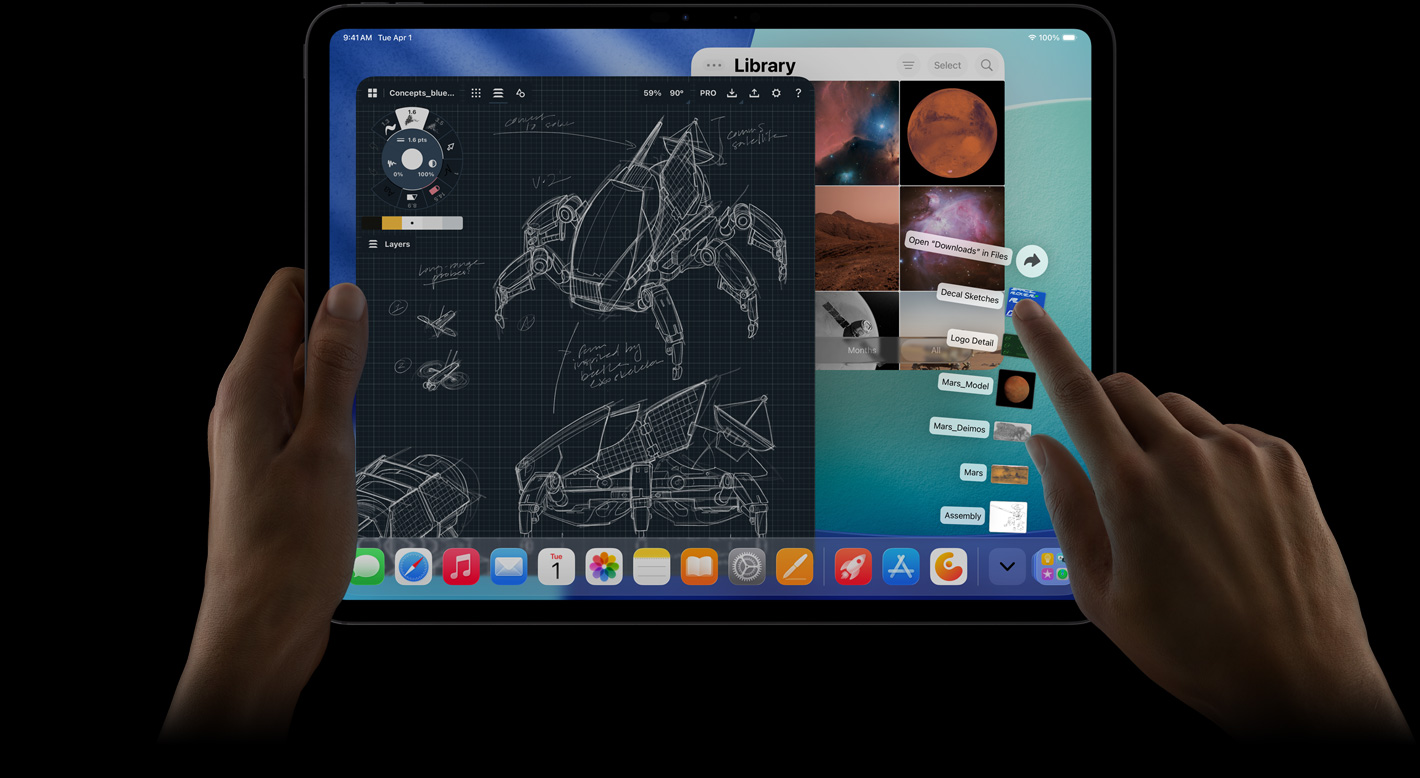 iPad Pro, esikülg, horisontaalpaigutus, parem käsi viipab üle lehvikuna laotatud allalaadimiste kausta failide, ekraan näitamas iPadOS 26 kasutajaliidest mitmete avatud rakendustega, sh pilditöötluse rakendus detailsete roboti kavanditega ja käsitsi kirjutatud märkmete ning mitmete kavandi etappidega, ja pildigalerii