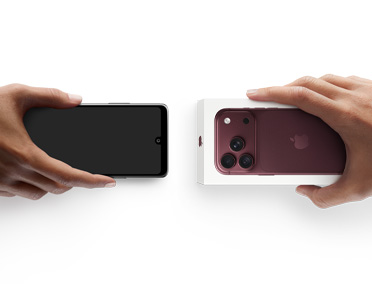 Dos manos intercambian teléfonos: un Android sin caja a la izquierda y un nuevo iPhone 18 Pro, color borgoña (rojo oscuro), en su caja, a la derecha