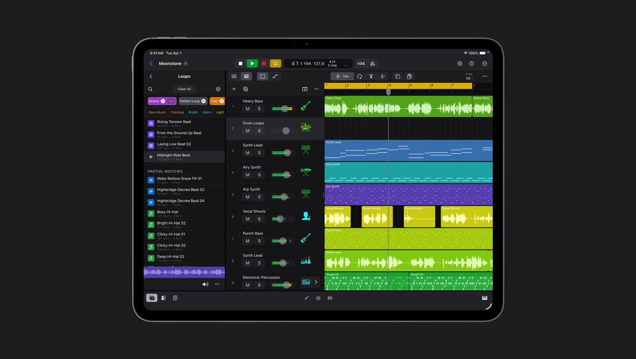 Layar iPad Pro 13 menampilkan ruang kerja Logic Pro, panel Loops di sebelah kiri, barisan gelombang suara dalam berbagai warna