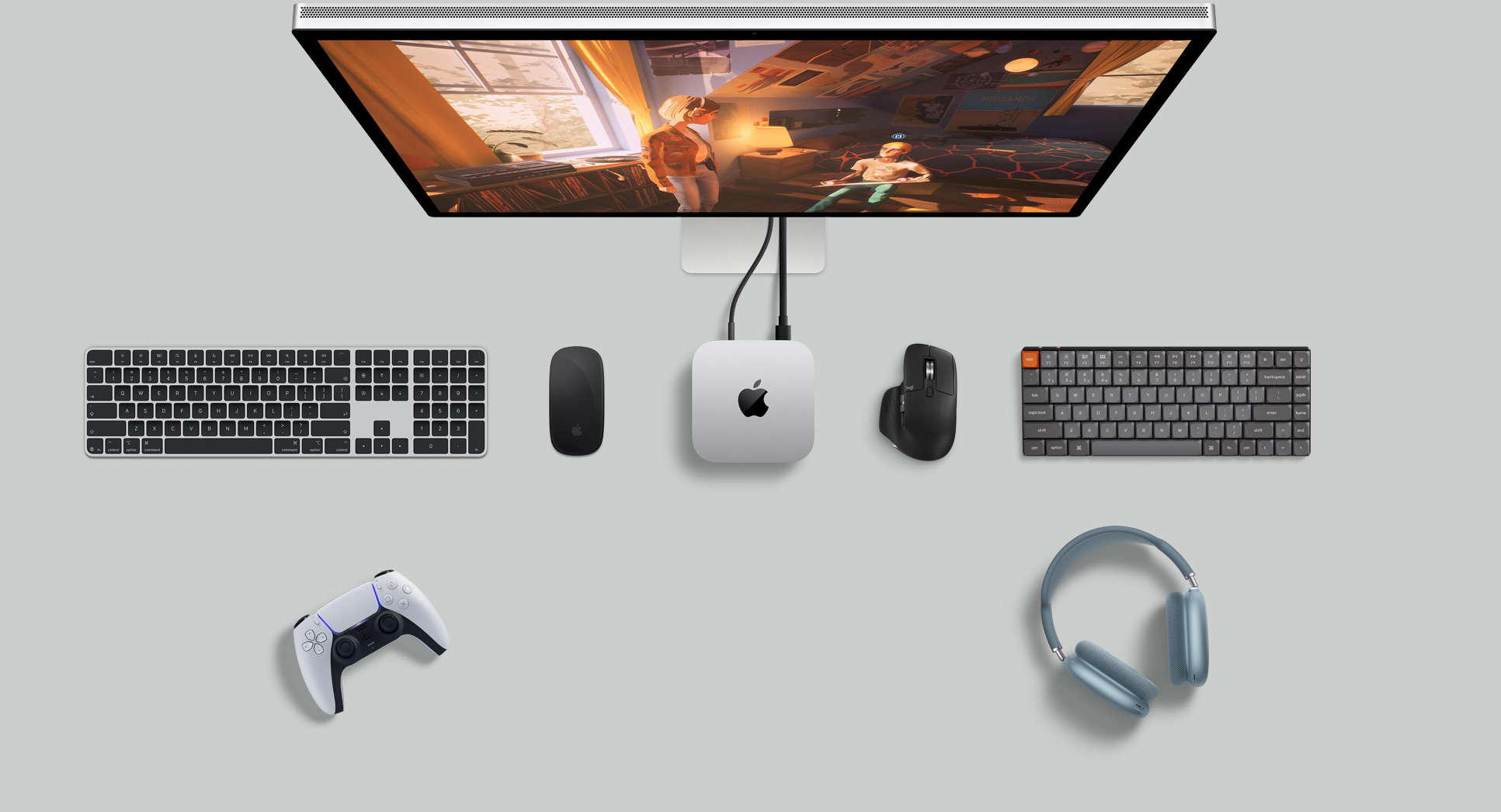 Vista desde arriba de un Mac mini sobre un escritorio con un Studio Display, teclados inalámbricos, dos ratones inalámbricos, un mando para videojuegos y unos AirPods Max