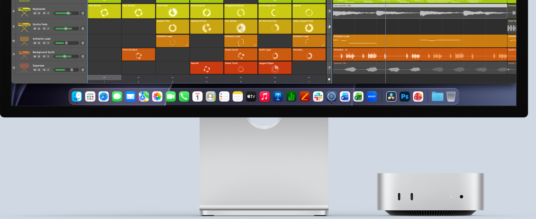 Mac mini, parte frontal, debajo de un Studio Display que muestra la interfaz de Logic Pro en la pantalla y apps de productividad en el Dock en la parte inferior