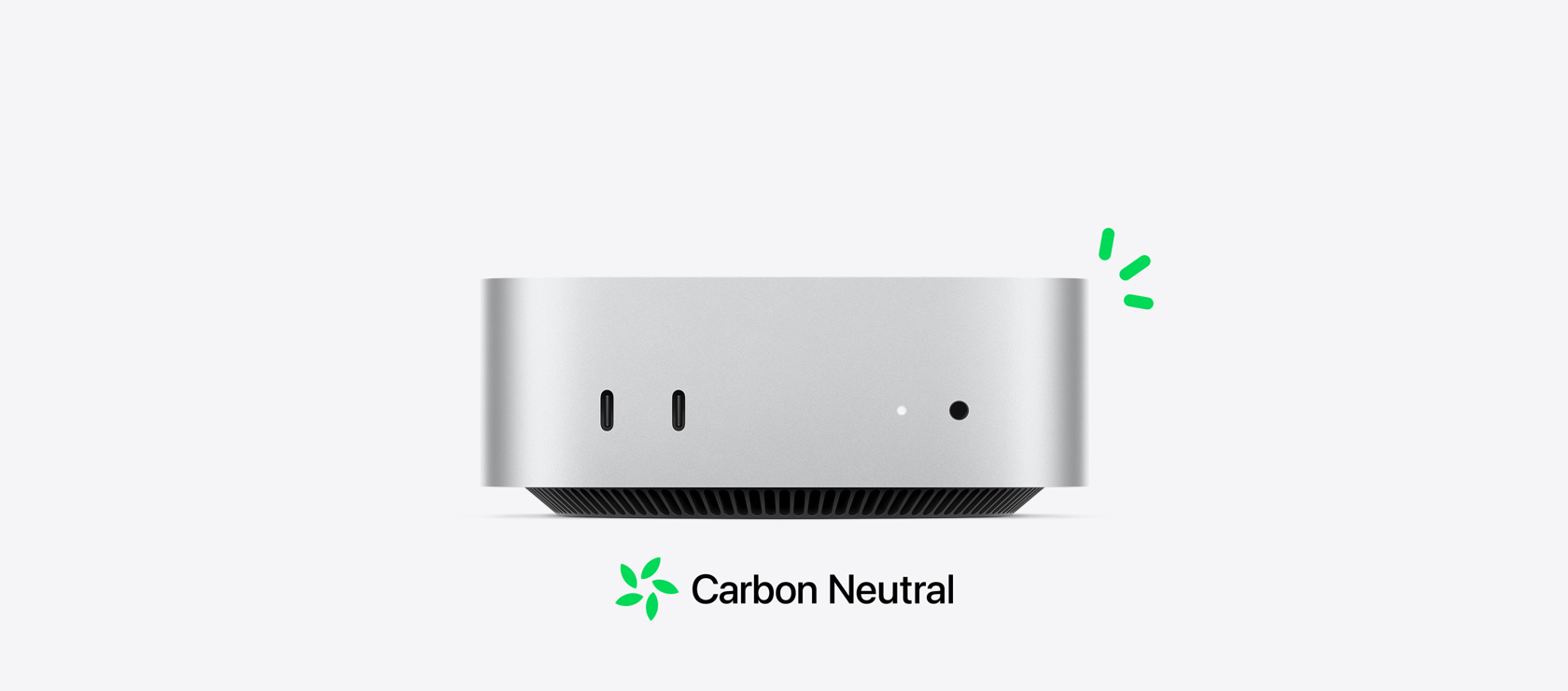 Vorderansicht eines Mac mini in Silber mit den Anschlüssen vorn, mit der CO₂ neutralen Story, veranschaulicht durch kleine grüne Akzente.