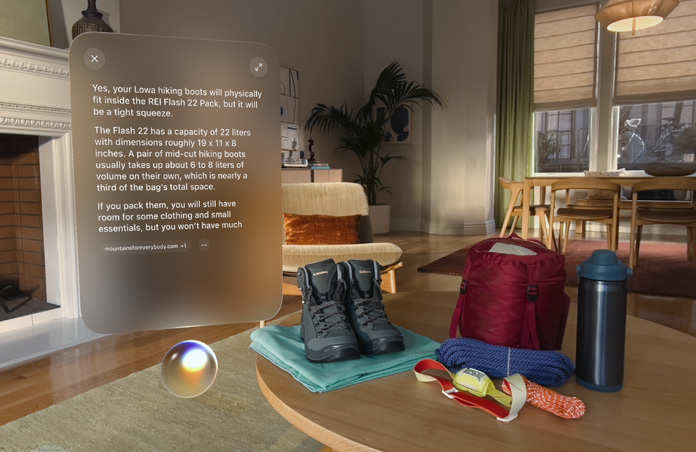 화면 왼쪽에는 캠핑 준비물에 관한 질문에 대한 Siri의 응답이 Siri Orb 위에 표시되어 있습니다. 화면 오른쪽 테이블 위에는 등산화, 로프, 배낭, 물병, 헤드램프가 놓여 있습니다.