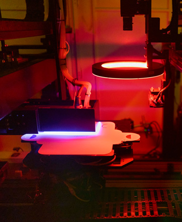 Manufacturing equipment illuminated by red and blue light in a factory