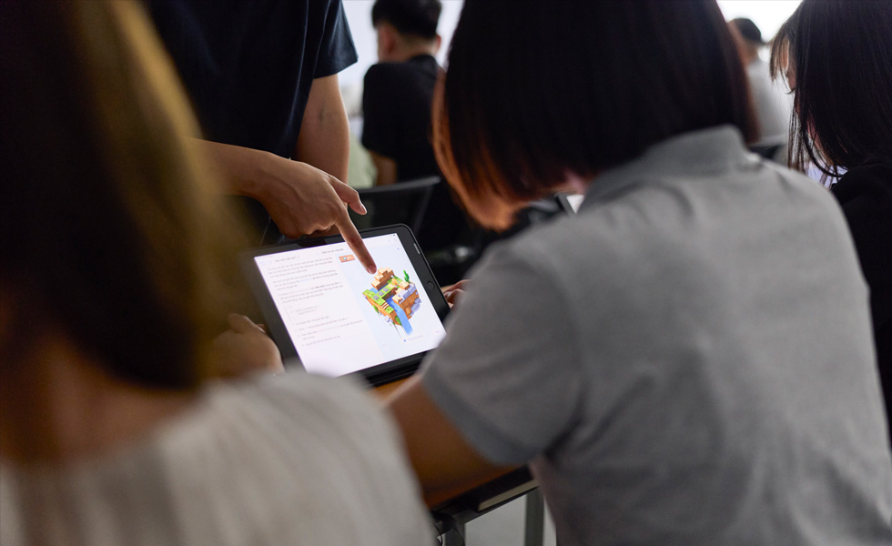 En person deler feedback om en genstand på en tablet i et klasseværelse